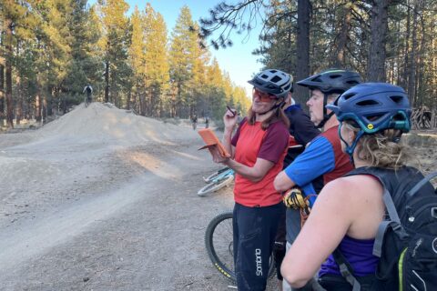 A mountain bike coach reviews video footage with her clients. 