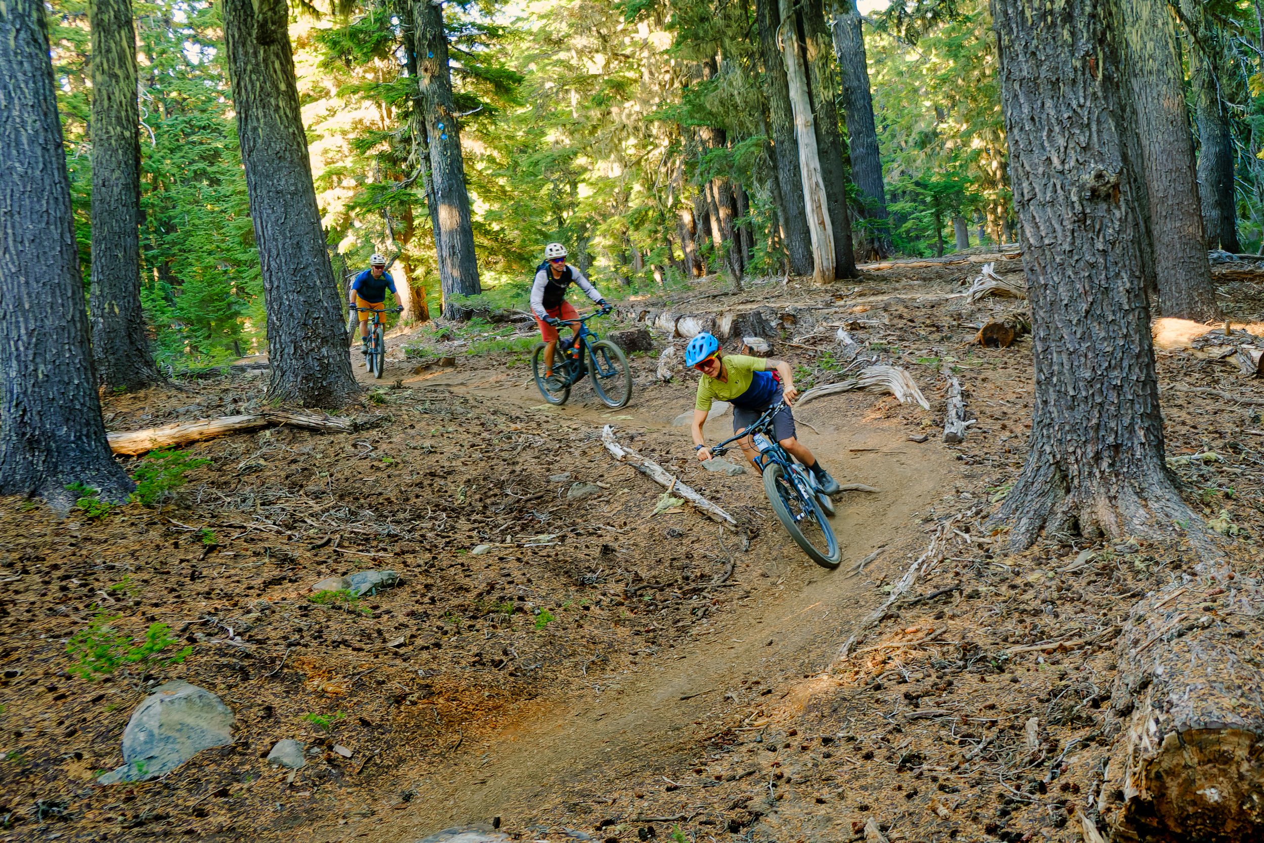 A mountain bike class practices body position on a forested trail near Bend, Oregon.
