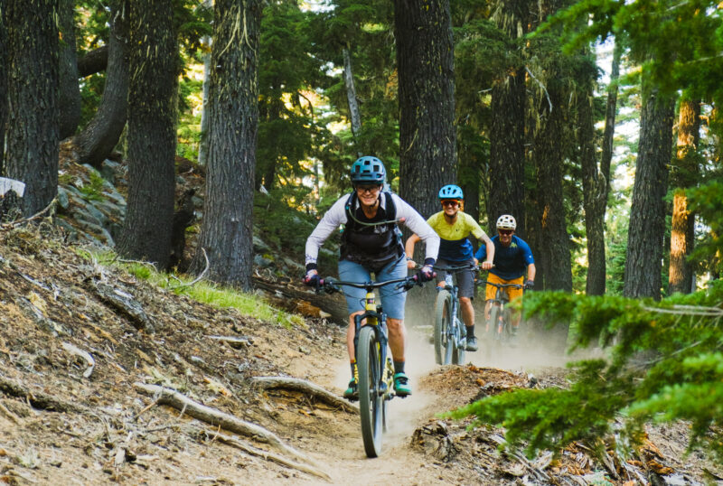 A guide leads her clients on a mountain bike ride on a forested trail near Bend, Oregon. 